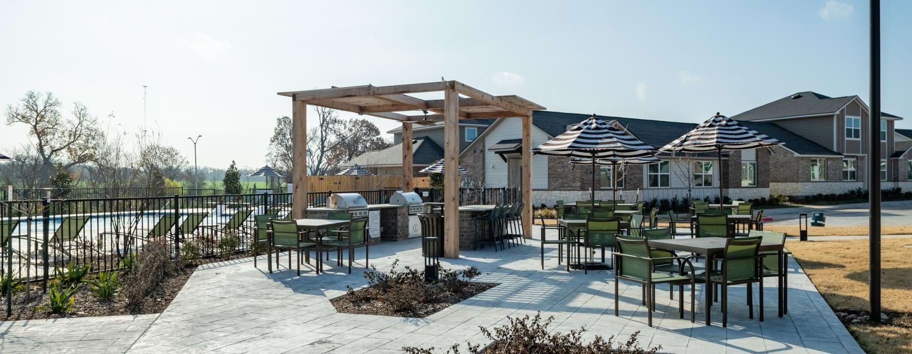 a patio with a table chairs and grills